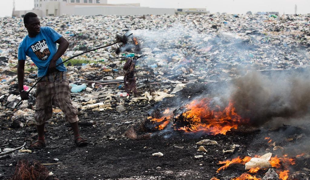 A worker in the 20-acre scrap yard in Agbogbloshie, Ghana burning insulated wire to recycle copper /©Jon Spaull